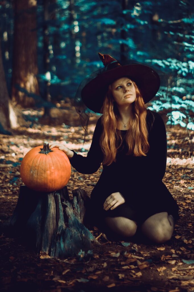 Fantasy-Portrait von Kimi-chan als Hexe in dunklem Outfit inmitten eines verwunschenen Waldes.