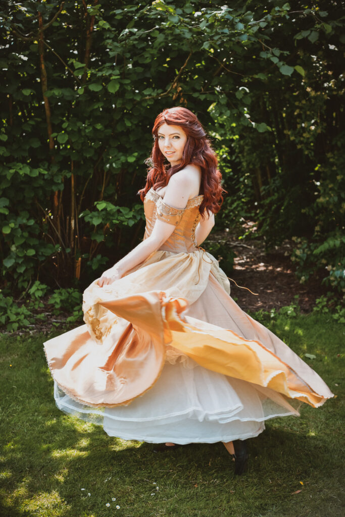 Ganzkörper Foto von Belle aus "Die Schöne und das Biest" wie sie sich in ihrem prächtiges Kleid dreht.