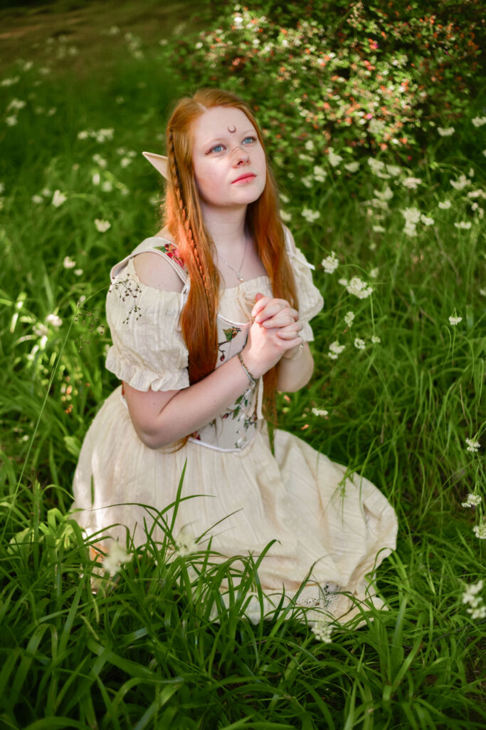 Kimi-chan als Elfe sitzt auf einer Wiese und betet für das Wohl ihres Volkes.