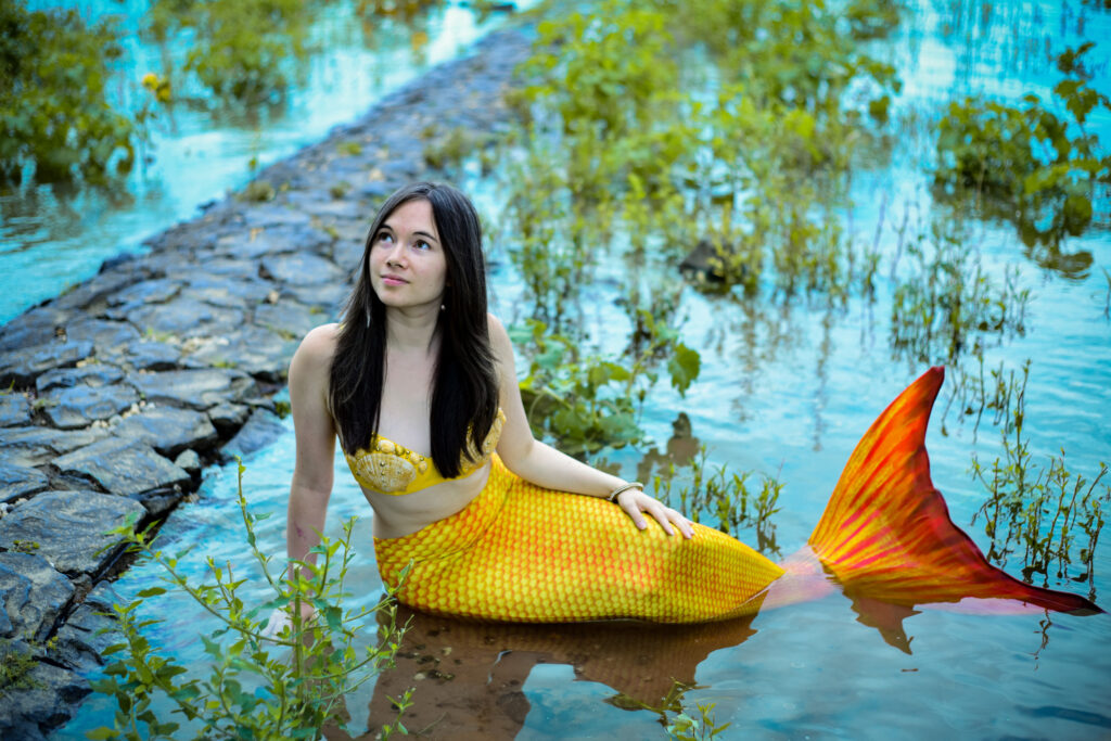 Ganzkörperfoto von Buchautorin Amy Thyndal als goldene Meerjungfrau bei einem Mermaidshooting in Wesseling bei Köln.