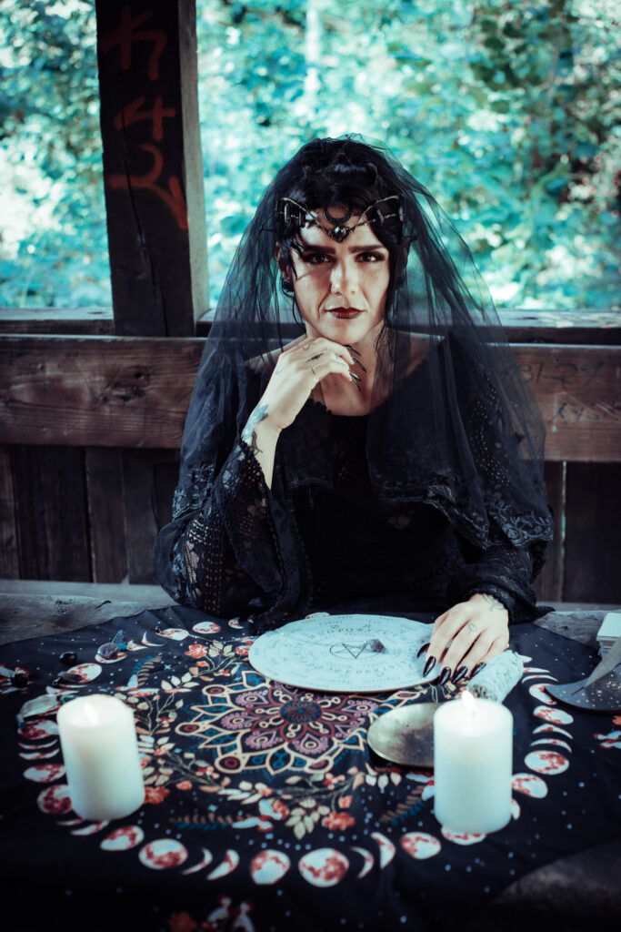 Dunkle Hexe bei einem Ritual mit Kerzen, Runen und magischem Tuch, Fantasy-Fotografie Köln.